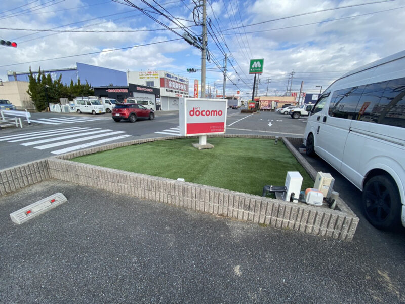 ドコモショップ施工事例　外看板周りの雑草対策で人工芝を敷く外構工事例